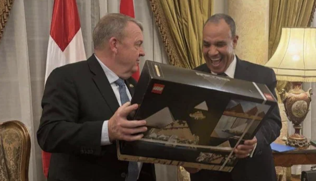 The Danish foreign minister and the Egyptian foreign minister share a laugh over a giant Lego pyramid gift