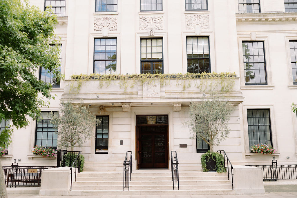 Art deco townhouse facade with olive trees on a quiet central London street