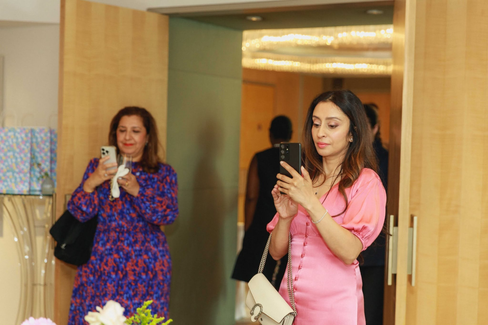 Guests arriving through the doors of the private suite, pausing to photograph the room