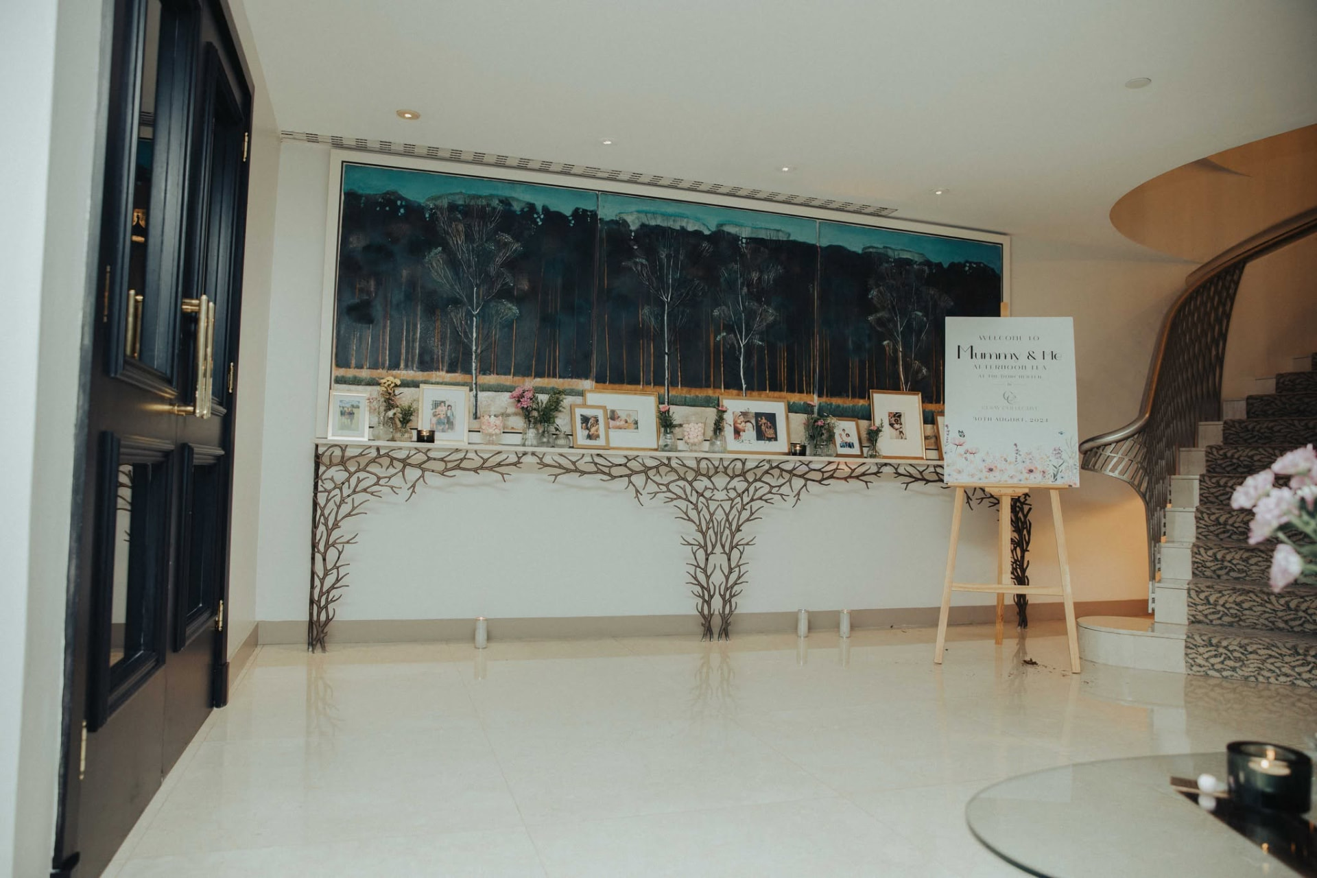 The entrance to the Mummy and Me afternoon tea, a welcome easel beside framed family portraits