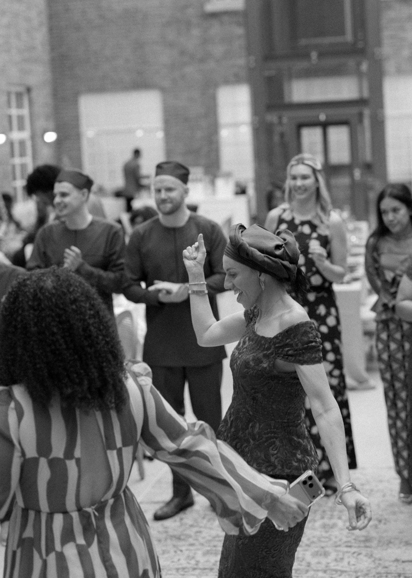 Guests dancing together at the reception, black and white