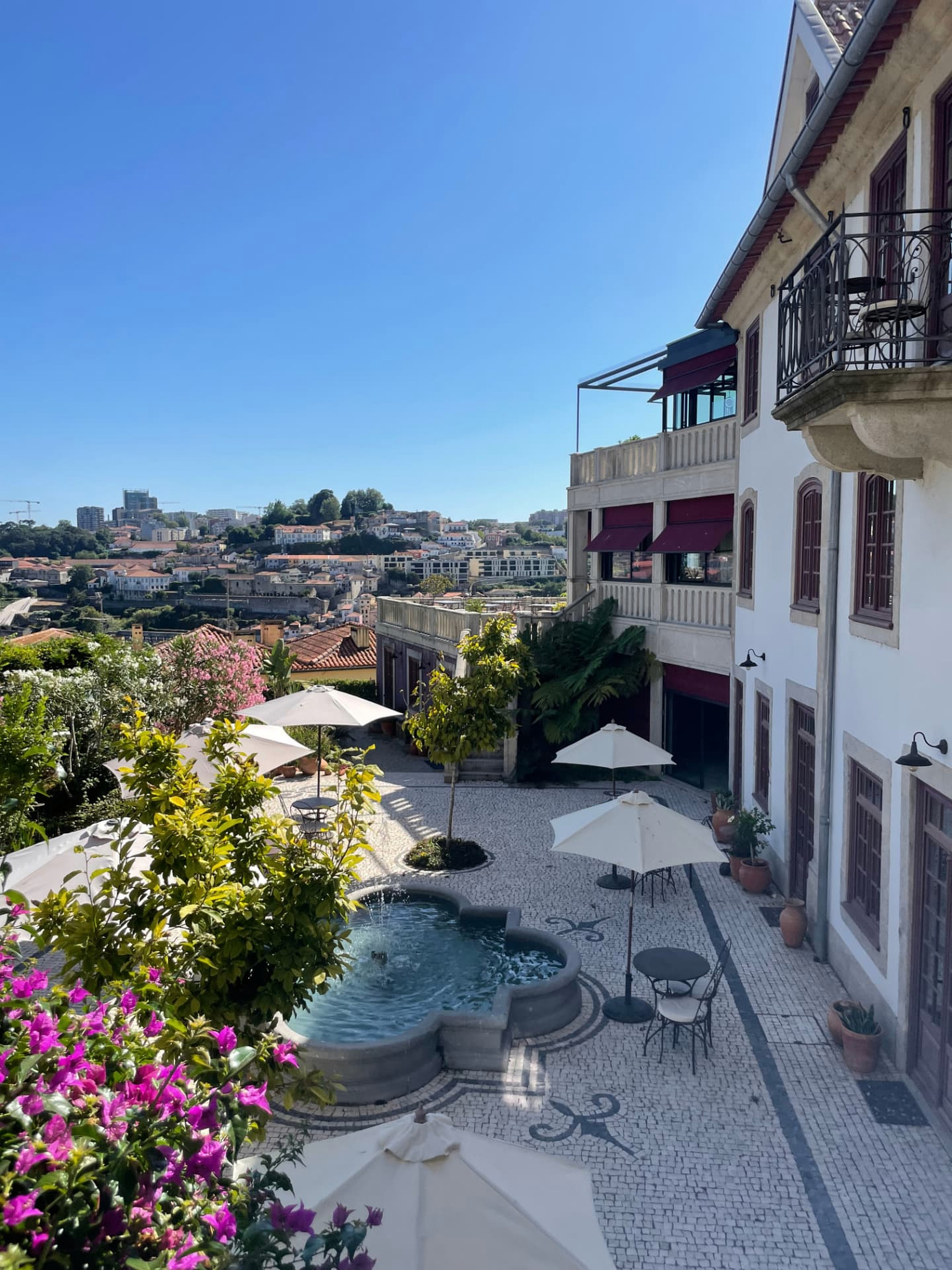 A garden courtyard terrace with a central fountain and Douro views at Casa Camélia