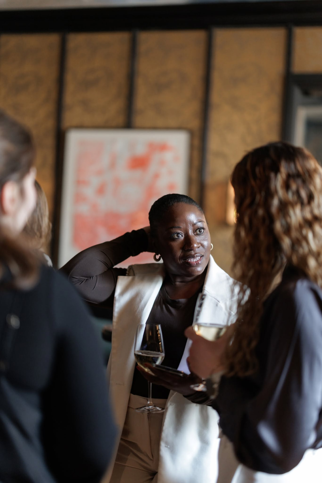The founder of MWP Collective mid-conversation with guests at an evening reception