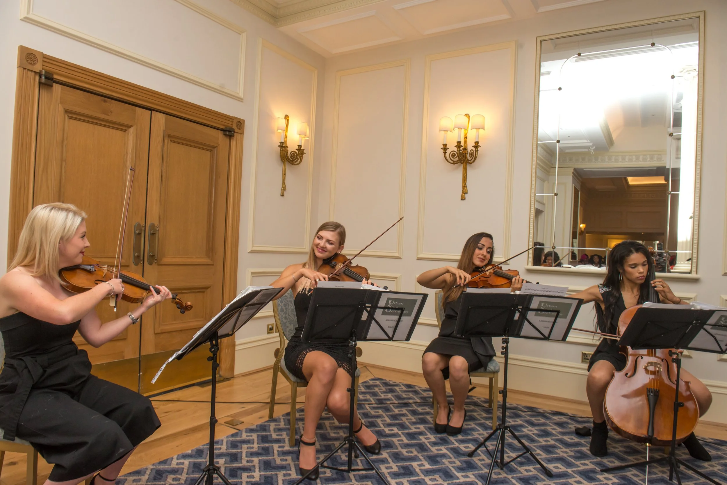 String quartet playing in a panelled reception room