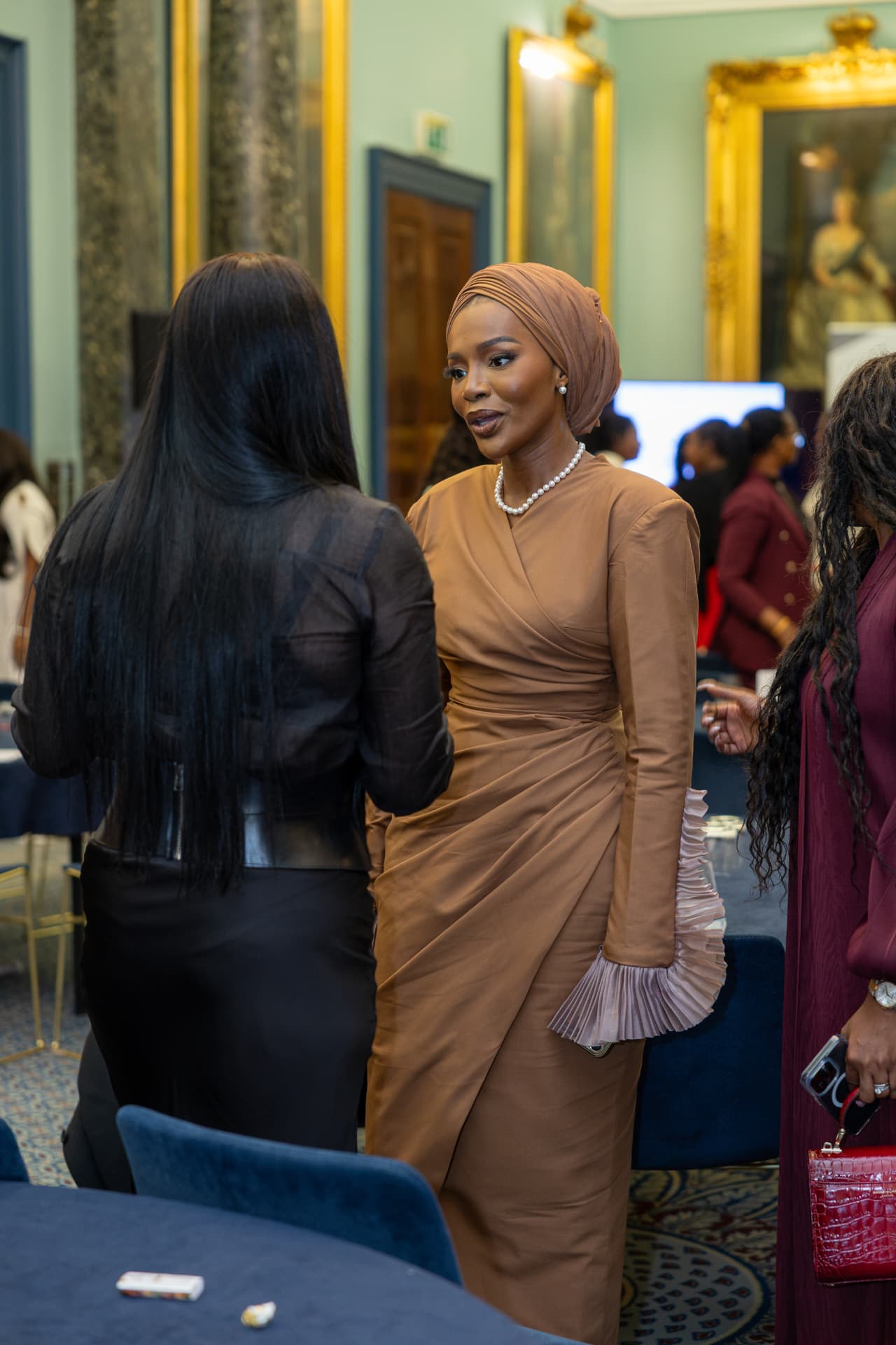A delegate in a tailored wrap dress in conversation during the symposium