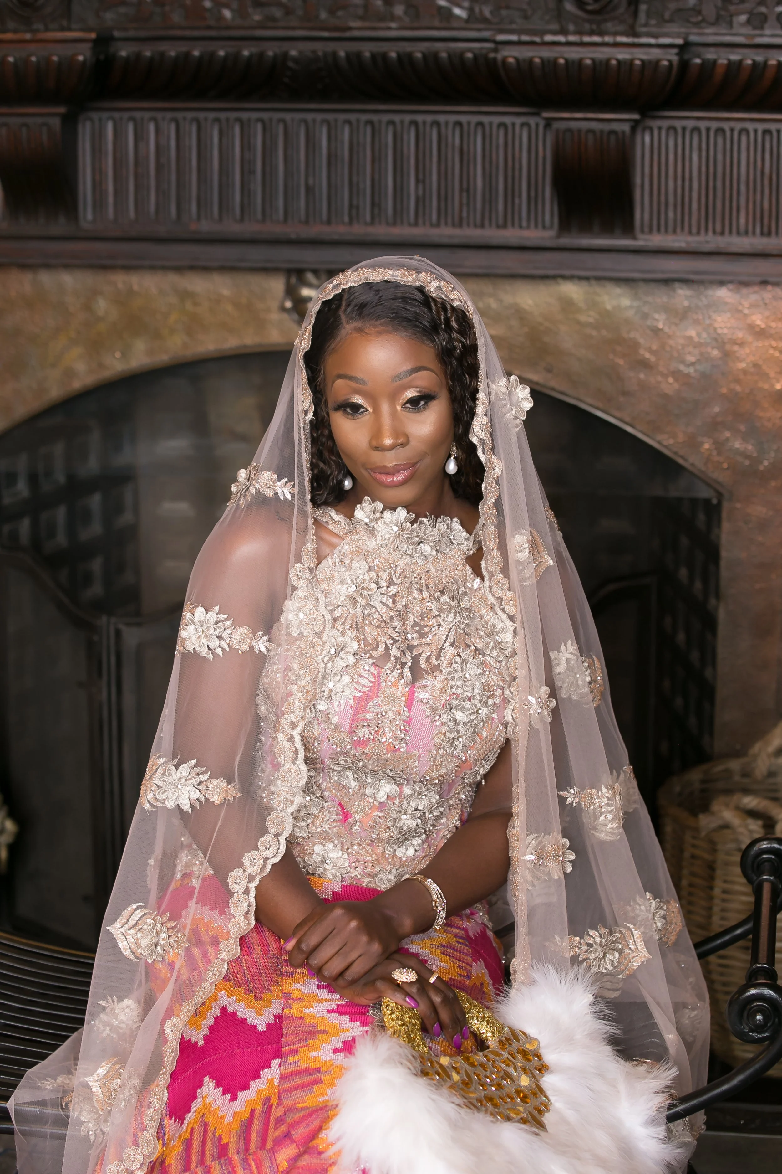 Bride seated in kente and a beaded veil during the traditional ceremony