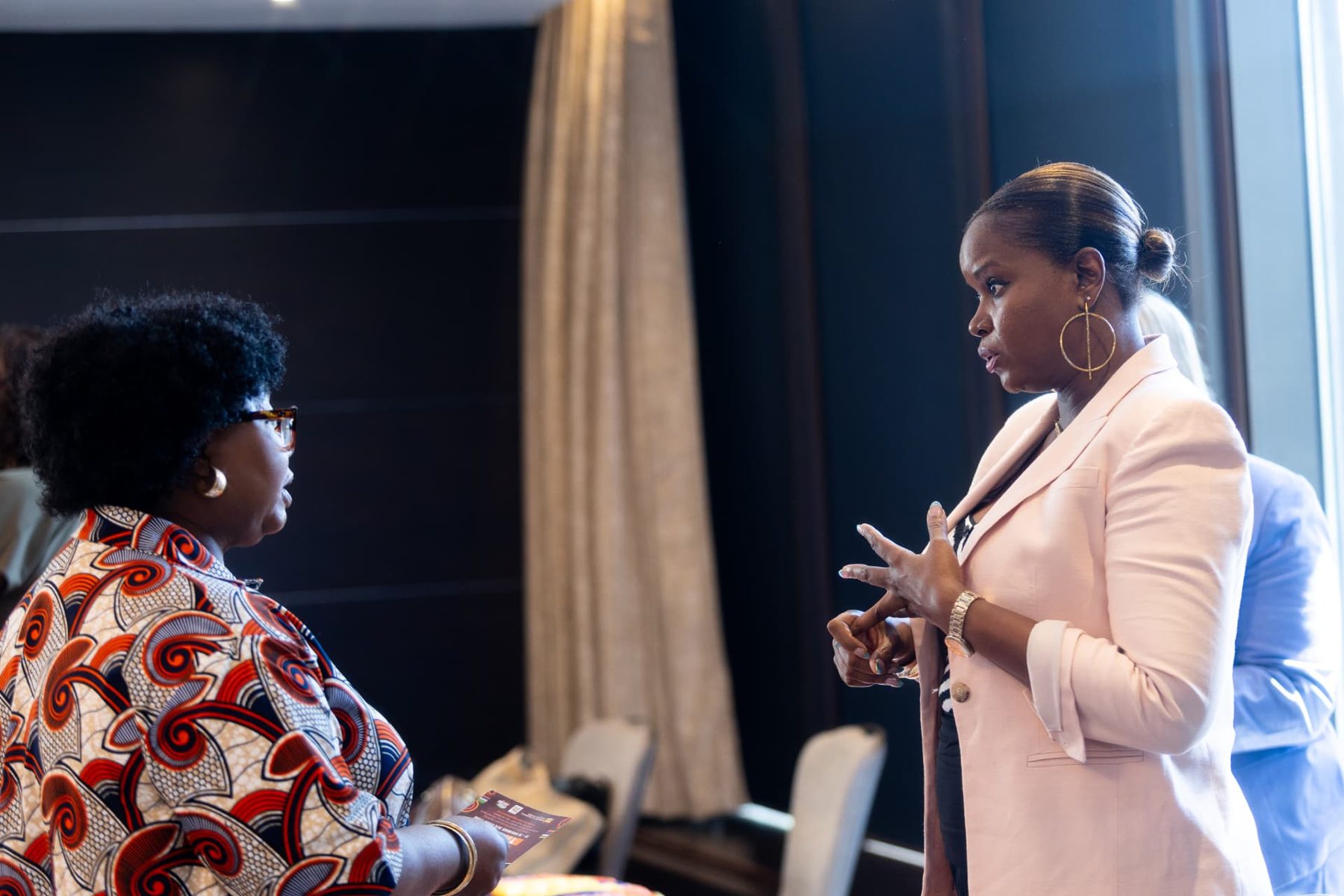 Delegates in conversation over a tablet at the conference