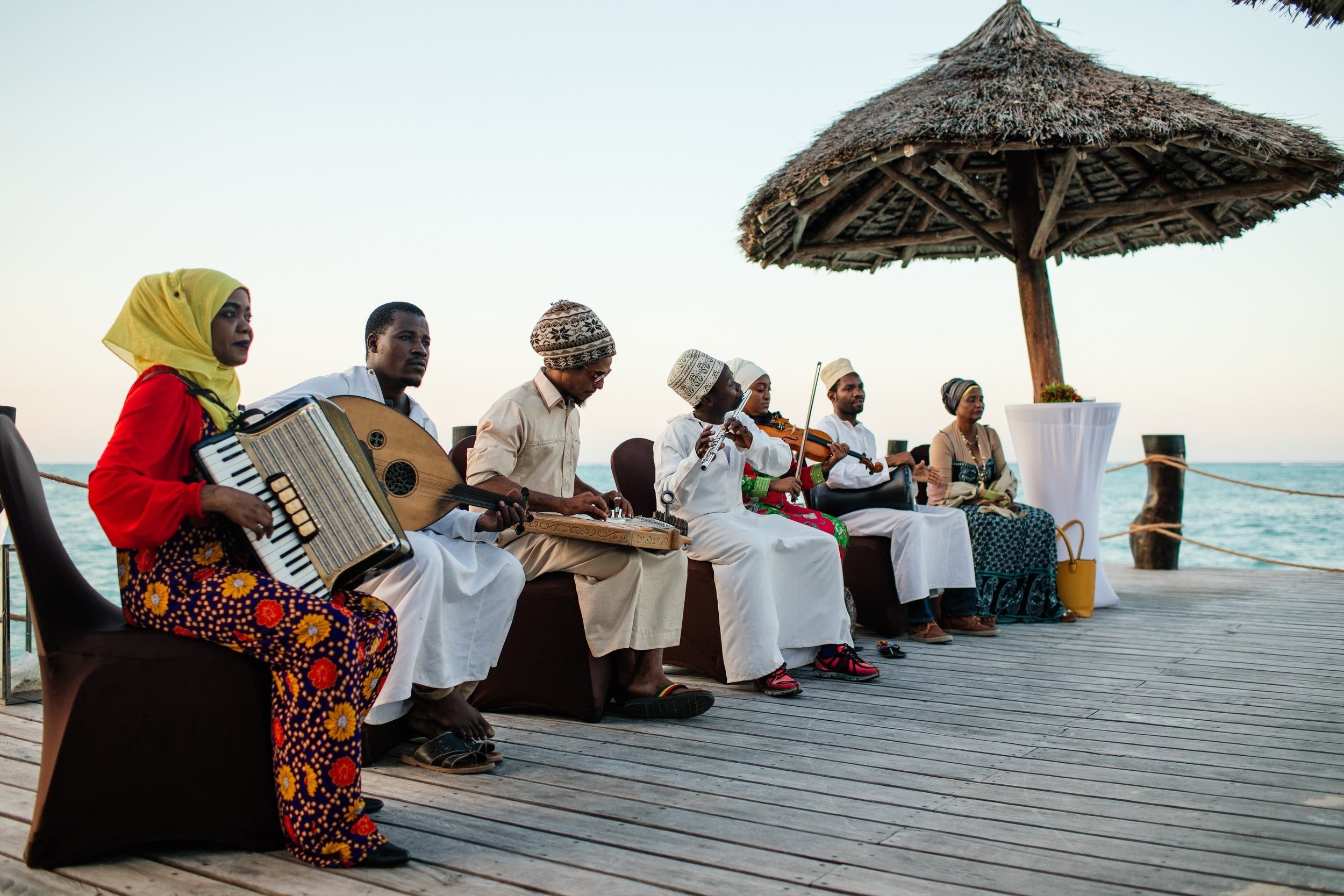 Taarab musicians playing on a deck at sunset in Zanzibar